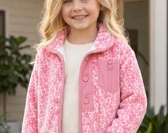 Puede incluir: Una chaqueta de forro polar con estampado de leopardo en rosa y blanco, con una tapeta de botones de pana rosa, un bolsillo en el pecho a juego con cremallera vertical, cuello vuelto y mangas largas con ribete rosa en puños y bajo.
