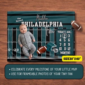 Może przedstawiać: Kocyk do zdjęć z kamieniami milowymi o tematyce futbolu amerykańskiego, o wymiarach 76 cm na 102 cm. Zawiera napis The Newest Madden Philadelphia Fan, grafikę piłki, kasku oraz kalendarz z liczbami od 1 do 12 oznaczającymi miesiące.