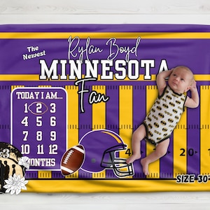 Puede incluir: Una manta de hitos morada y amarilla con diseño de campo de fútbol, el texto 'The Newest Rylan Boyd MINNESOTA Fan', un rastreador mensual 'TODAY I AM', un balón de fútbol americano y un casco. La manta mide 76 cm por 102 cm.