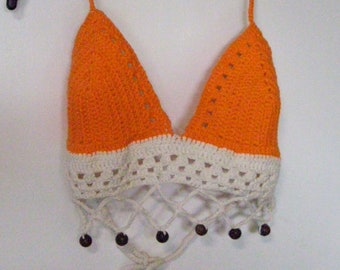 May include: Orange and white crocheted halter top with a white crocheted trim and brown beads.