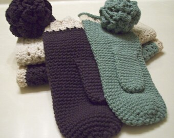 May include: A set of three crocheted fingerless gloves in brown, white, and green. The gloves are made with a textured stitch and have a pom-pom on the top.