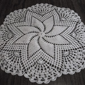 May include: White crocheted doily with a spiral design in the center.