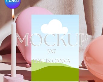 May include: A mockup design featuring a 5x7 inch card with a blue sky and green hill illustration, the word "MOCKUP" and "EDIT IN CANVA" text. A lit white candle, pink balloons, and a pen are also in the image.
