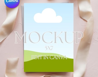 May include: A 5x7 inch mockup card with a blue sky and cloud design, green hills, and the word "MOCKUP" in large, gray letters. The words "EDIT IN CANVA" are at the bottom. A Canva logo is in the upper left corner. The card is surrounded by a cream-colored ribbon.