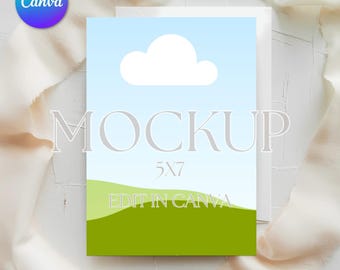May include: A 5x7 inch mockup card with a landscape design featuring a blue sky, white cloud, and green hills. The word "MOCKUP" is displayed in large, gray letters, with "EDIT IN CANVA" at the bottom.