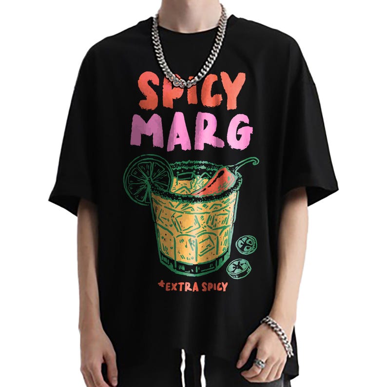 May include: Black t-shirt with a colorful graphic of a spicy margarita cocktail. The text "SPICY MARG" is above the cocktail illustration, and "EXTRA SPICY" is below. The design includes a lime slice and a chili pepper.