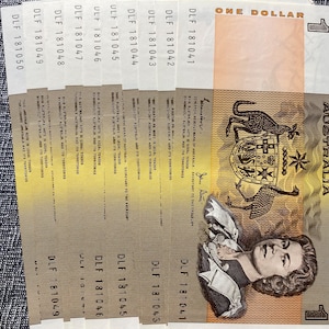 May include: A stack of eight Australian one dollar banknotes featuring a portrait of Queen Elizabeth II and the Australian coat of arms. The notes are in good condition and have the serial numbers DLF 181050, DLF 181049, DLF 181048, DLF 181047, DLF 181046, DLF 181045, DLF 181044, and DLF 181043.