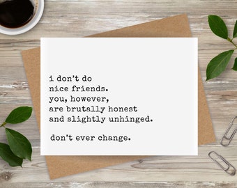 Peut inclure: Une carte de vœux blanche avec du texte noir : "i don't do nice friends. you, however, are brutally honest and slightly unhinged. don't ever change." La carte est posée sur une enveloppe marron, avec du café et des feuilles en arrière-plan.