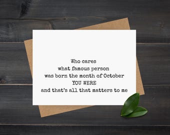 May include: A white greeting card with the text "Who cares what famous person was born the month of October YOU WERE and that's all that matters to me" is placed on a brown envelope. Two green leaves are in the bottom right corner.