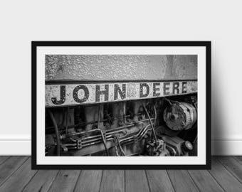 Puede incluir: Foto en blanco y negro de un motor de tractor John Deere. El motor está cubierto de suciedad y mugre, y el logotipo de John Deere es visible en el lateral.