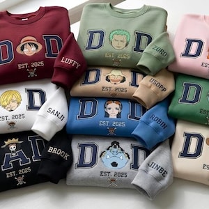 Può includere: Una collezione di felpe in vari colori, ognuna con la parola "DAD" in lettere maiuscole blu navy, un'illustrazione di personaggio e "EST. 2025". Le maniche sono ricamate con i nomi dei personaggi.