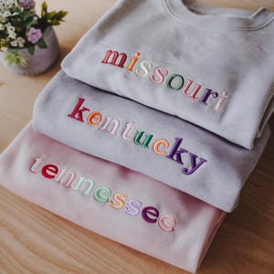 Sudadera con bordado estatal personalizado, cuello redondo con letras multicolor, camisa colorida personalizada, regalo preppy para ella, regalo para viajeros de EE. UU.