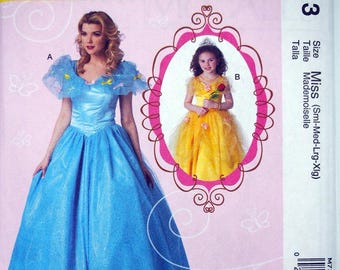 May include: McCall's Costumes pattern M7213 featuring two princess dress designs. One dress is a long, light blue gown with a fitted bodice and full skirt. The other is a yellow dress with a tulle skirt. The pattern includes sizes for Miss (Sml-Med-Lrg-Xlg).