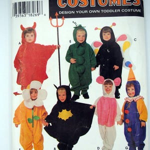 May include: A Simplicity Costumes sewing pattern envelope for toddler costumes, number 0643, size A. The front displays illustrations of seven different costumes including a red devil, green pea pod, butterfly, flower, bat, mouse, and a colorful clown outfit.