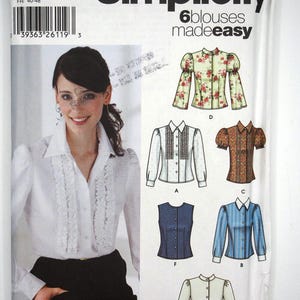 May include: Simplicity sewing pattern 5872 featuring six blouse designs. The pattern includes a variety of styles, from a floral print blouse to a striped button-down. The package shows a woman wearing a white blouse with ruffled detailing.
