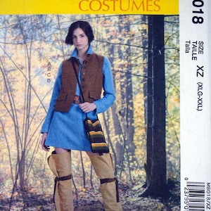 Pode incluir: Padrão de fantasias McCall's M8018 com uma mulher em um vestido azul, colete marrom e botas de cano alto bege. O padrão inclui tamanhos XZ (XLG-XXL). O fundo mostra uma cena de floresta.