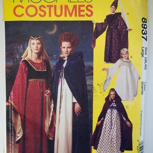 Może przedstawiać: Wykrój krawiecki McCall's Costumes 8937 w rozmiarze Large. Koperta zawiera ilustracje trzech różnych sukien i peleryn w stylu średniowiecznym w kolorach czerwonym, białym i niebieskim, ze złotymi akcentami. Tekst zawiera nazwę marki i numer wzoru.