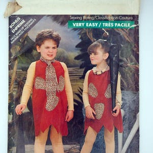 May include: Butterick sewing pattern 5806 featuring children's costumes. The pattern includes instructions for making costumes with red tunics, animal print accents, and accessories. The packaging includes the text "VERY EASY / TRÈS FACILE".