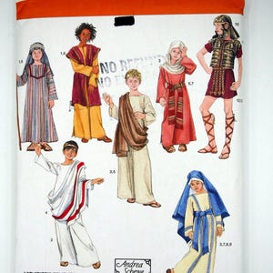 May include: Simplicity sewing pattern 2976 for historical costumes in sizes XS, S, M, L. The package features illustrations of seven figures wearing various tunics, robes, a Roman-style breastplate, and head coverings with numbered references.