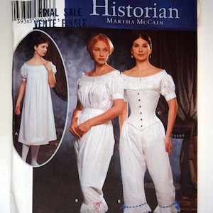 May include: A Simplicity sewing pattern for a white, long-sleeved, high-waisted blouse and white, high-waisted pants. The pattern is for sizes 14, 16, 18, and 20. The pattern is titled "The Fashion Historian" by Martha McCain.