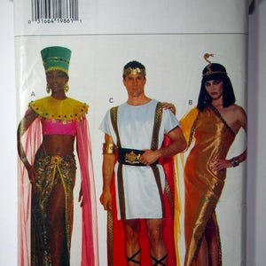Peut inclure: Un patron de couture pour trois costumes : une tunique de style romain dorée et rouge avec une cape rouge, une robe de style égyptien dorée et marron avec une cape rose et une robe de style égyptien dorée et marron avec un serre-tête en forme de serpent doré. Le patron est pour toutes les tailles et est de la marque Butterick.