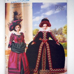 May include: Vogue Craft pattern featuring two doll designs. One doll wears a red and black dress with a matching hat. The other doll is in a black dress with red and gold trim and a white collar. The pattern is designed by Linda Carr.