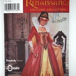 May include: A Simplicity Renaissance Costume Collection sewing pattern for a red and gold gown with a white fur collar and a mask. The pattern number is 9832 and the sizes are HH 6, 8, 10, 12. The pattern is designed by Patti Wagner Miller.