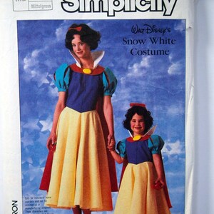 Op de afbeelding: Simplicity naaipatroon voor een Sneeuwwitje kostuum. Het patroon bevat instructies voor het maken van een jurk en een cape voor zowel een kind als een volwassene. De patroonhoes toont een foto van twee meisjes die verkleed zijn als Sneeuwwitje.