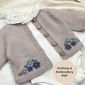 May include: A lilac knitted baby cardigan with wooden buttons and blue floral embroidery. The cardigan is layered over a white onesie with a white ruffled collar. The image includes the text "Knitting & Embroidery PDF".