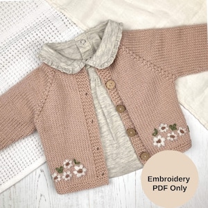 Könnte beinhalten: Hellrosa Baby-Strickjacke mit grauem Kragen und grauem Hemd darunter. Die Strickjacke hat Holzknöpfe und gestickte weiße Blumen mit grünen Blättern. Der Text "Embroidery PDF Only" befindet sich in einem Kreis.