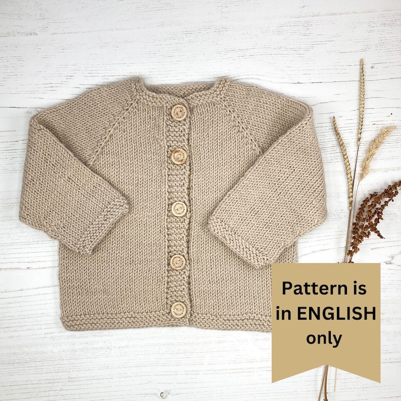 May include: A beige long-sleeve knit cardigan featuring a round neckline and five light brown wooden buttons down the center front. A tan banner overlay on the right side displays the text: Pattern is in ENGLISH only.