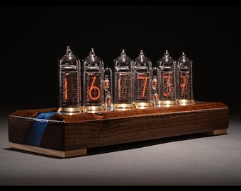 May include: A wooden clock with a dark brown finish and blue accents. The clock face is made up of six clear glass tubes with red glowing numbers inside.