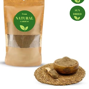 Może przedstawiać: Brązowa papierowa torba z zieloną etykietą, na której widnieje napis "From Natural Gardens". Torba zawiera brązowy proszek. W górnym prawym rogu znajdują się dwie zielone etykiety z białym tekstem. Jedna etykieta głosi "100% Organic", a druga "Sun Dried".