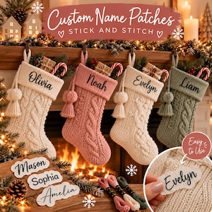 Op de afbeelding: Vier kerstsokken van kabelgebreid materiaal in crème, roze, crème en saliegroen, elk voorzien van een gepersonaliseerde naam in zwart schrift. De sokken hebben bijpassende kwastjes en worden getoond met naamlabels en borduurgaren.