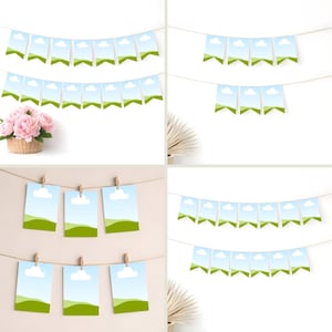 May include: A collection of decorative banners and photo displays. The banners feature a blue sky and green landscape design. Some photos are clipped to a string with wooden clips. A basket of pink flowers is in the background.