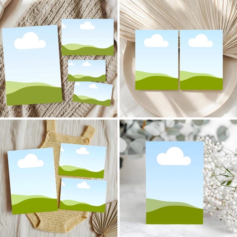 May include: A collection of cards with a landscape design featuring a blue sky, white cloud, and green hills. The cards vary in size and are arranged on different textured surfaces, including a knitted blanket and a white plate.