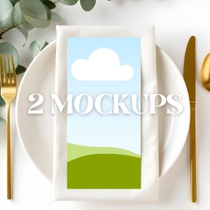 May include: A mockup card with a sky and cloud design, displayed on a white plate with gold cutlery. The card features a blue sky, white cloud, and green hills. The text "2 MOCKUPS" is displayed on the card.