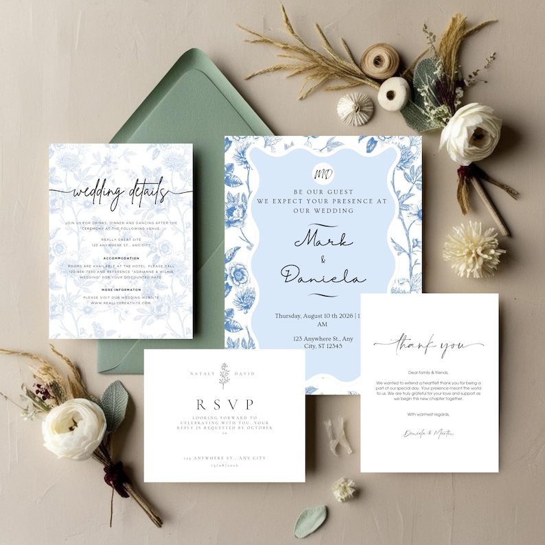 May include: A collection of wedding stationery, including invitations, RSVP cards, and thank you notes. The designs feature floral patterns and elegant calligraphy in shades of blue and white. A green envelope is also included.