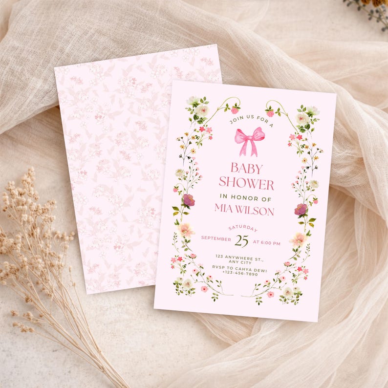 K&ouml;nnte beinhalten: Eine hellrosa Babyparty-Einladungskarte mit einem Blumenkranz-Rand, einer rosa Schleifenillustration und dem Text Join us for a baby shower in honor of Mia Wilson, Saturday September 25 at 6:00 PM, 123 Anywhere St., Any City, RSVP to Cahya Dewi +123-456-7890.