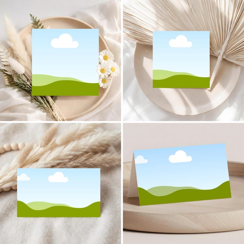 May include: Four cards with a landscape design featuring a blue sky with a white cloud and green rolling hills. The cards are arranged on a beige plate with dried flowers and a wooden tray.