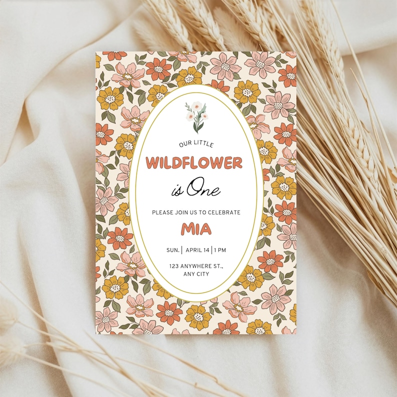 K&ouml;nnte beinhalten: Eine rechteckige Einladungskarte mit cremefarbenem Hintergrund und einem wiederkehrenden Muster aus rosa, orangefarbenen und gelben Blumen. Ein zentrales wei&szlig;es Oval enth&auml;lt den Text: Our Little Wildflower is One, Please Join Us to Celebrate, Mia, Sun. April 14, 1 PM, 123 Anywhere St., Any City.