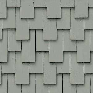 Op de afbeelding: Een close-up van een muur bedekt met grijze houten shingles. De shingles zijn in een verspringend patroon gerangschikt, waardoor een textuur ontstaat.