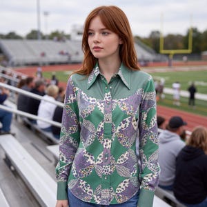 May include: A long-sleeved button-down shirt featuring a solid sage green yoke and collar, paired with a repeating circular pattern in shades of purple, green, and cream. The shirt has a pointed collar, buttoned cuffs, and a front button closure.