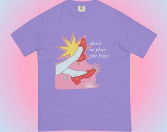 Puede incluir: Camiseta morada con un gráfico de zapatos rojos y el texto "there's no place like home".