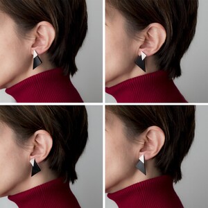 Puede incluir: Dos personas con pendientes triangulares en blanco y negro. Los pendientes son de estilo geom&eacute;trico y moderno.