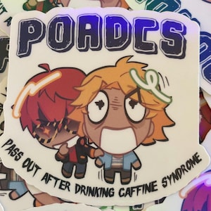 May include: A white sticker with the word "POADES" in blue letters. The sticker features two cartoon characters, one with red hair and the other with yellow hair, with the text "PASS OUT AFTER DRINKING CAFFINE SYNDROME".