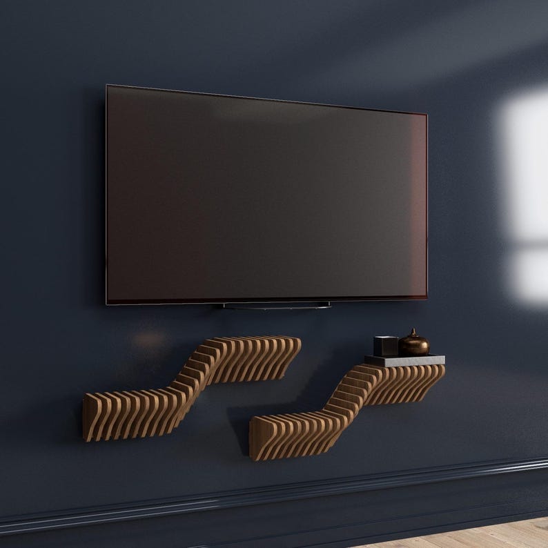 Pu&ograve; includere: Un muro blu scuro con una TV a schermo piatto montata sopra due mensole in legno. Le mensole sono curve e hanno un design ondulato.