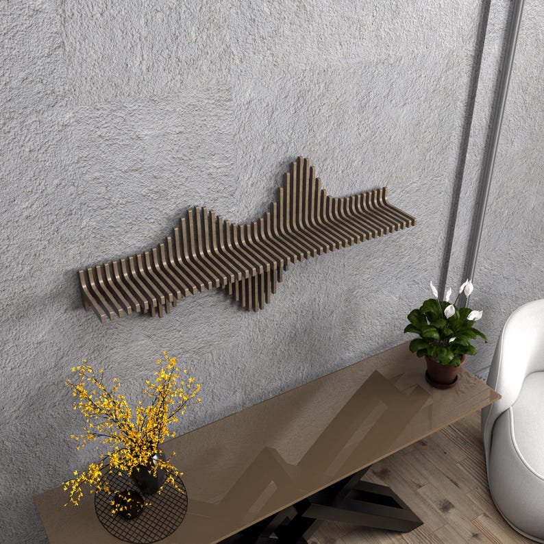 Op de afbeelding: Een bruine houten wandplank met een uniek golvend ontwerp. De plank is gemonteerd op een grijze muur en heeft een moderne, minimalistische esthetiek.