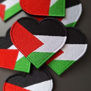 Può includere: Cinque toppe a forma di cuore con i colori della bandiera palestinese: nero, bianco, rosso e verde. Le toppe sono fatte di tessuto e hanno un design cucito.