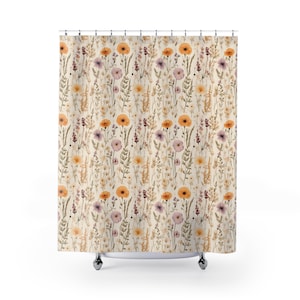 May include: A floral shower curtain featuring a repeating pattern of watercolor wildflowers in shades of orange, purple, and yellow on a cream background. The curtain is hanging from a metal rod with chrome-colored rings.